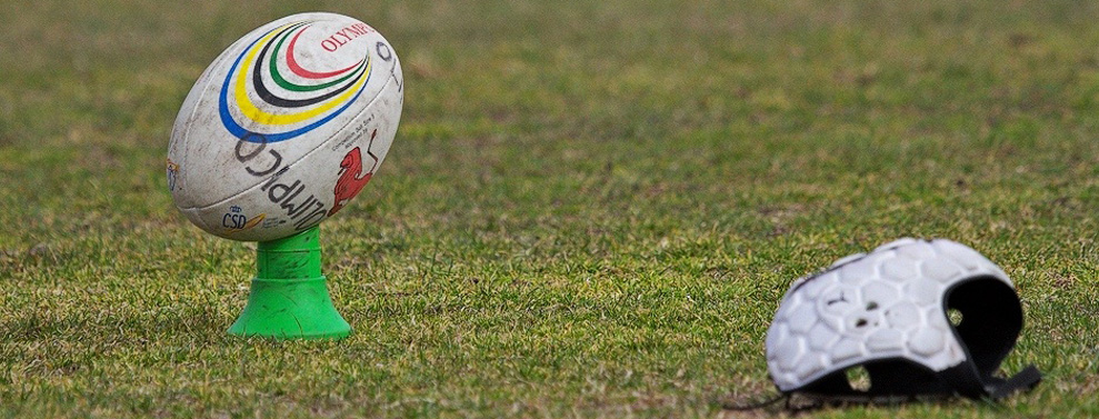 Rugby ball and scrum cap on a field